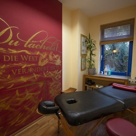 Massageraum mit Wandposter und Massagestuhl