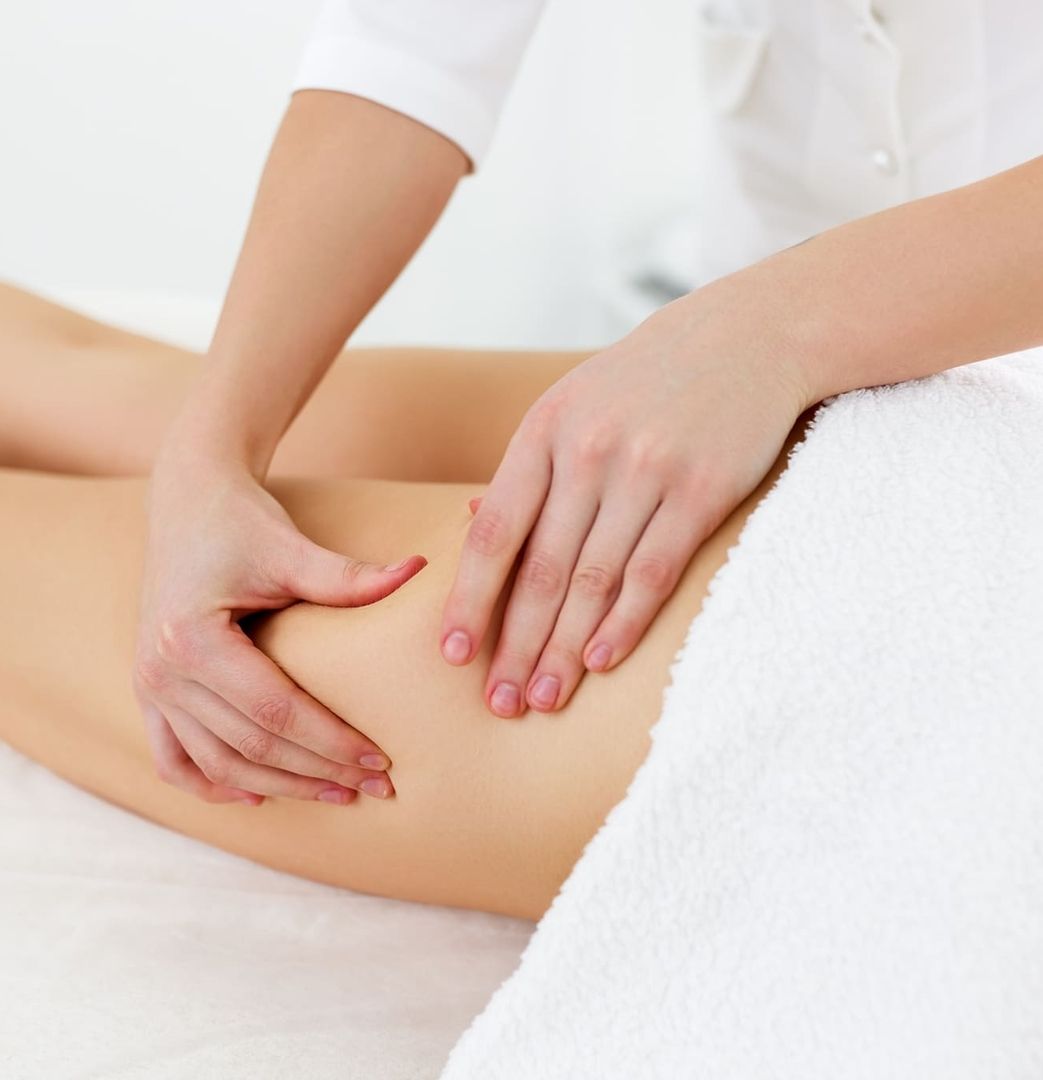 Physiotherapeutin macht Lymphdrainage-Massage an dem Bein einer Person